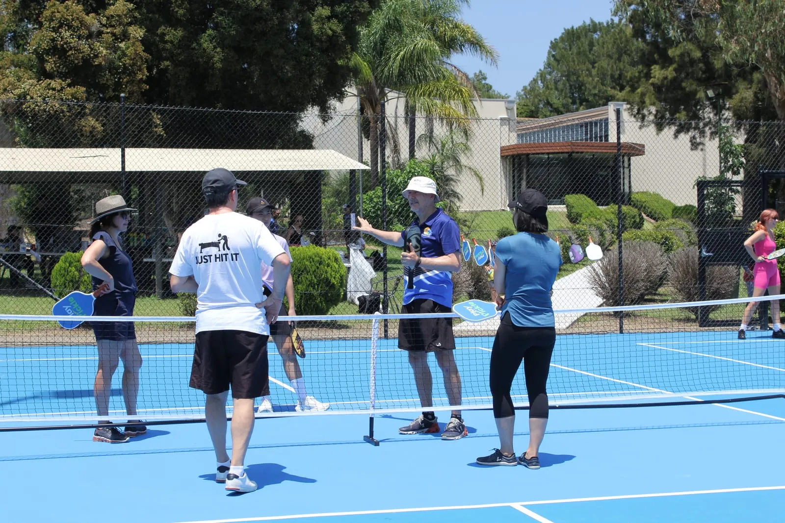 A coach running a lesson with players at the net