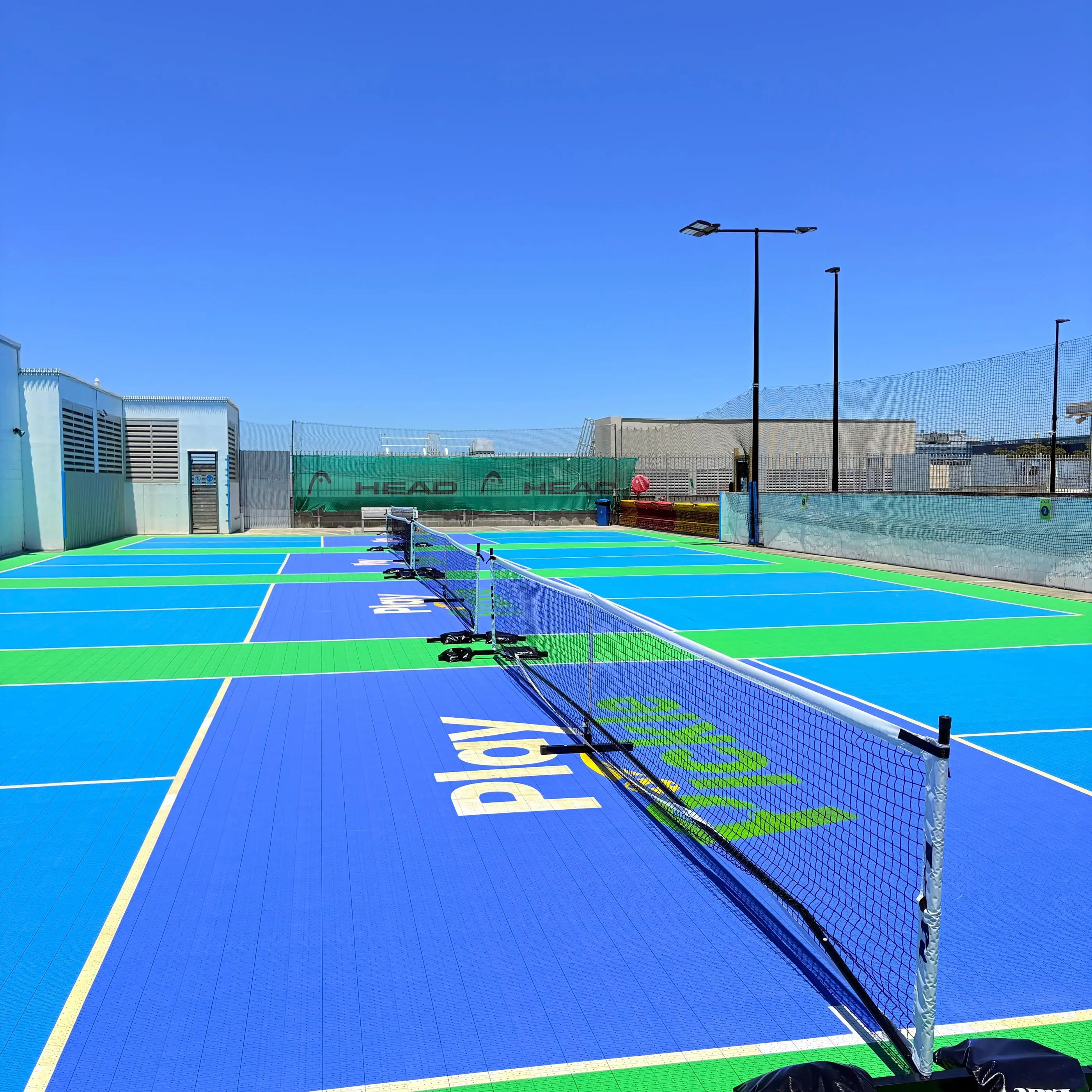 Pickleball paddles, balls and nets on the rooftop courts at Broadway