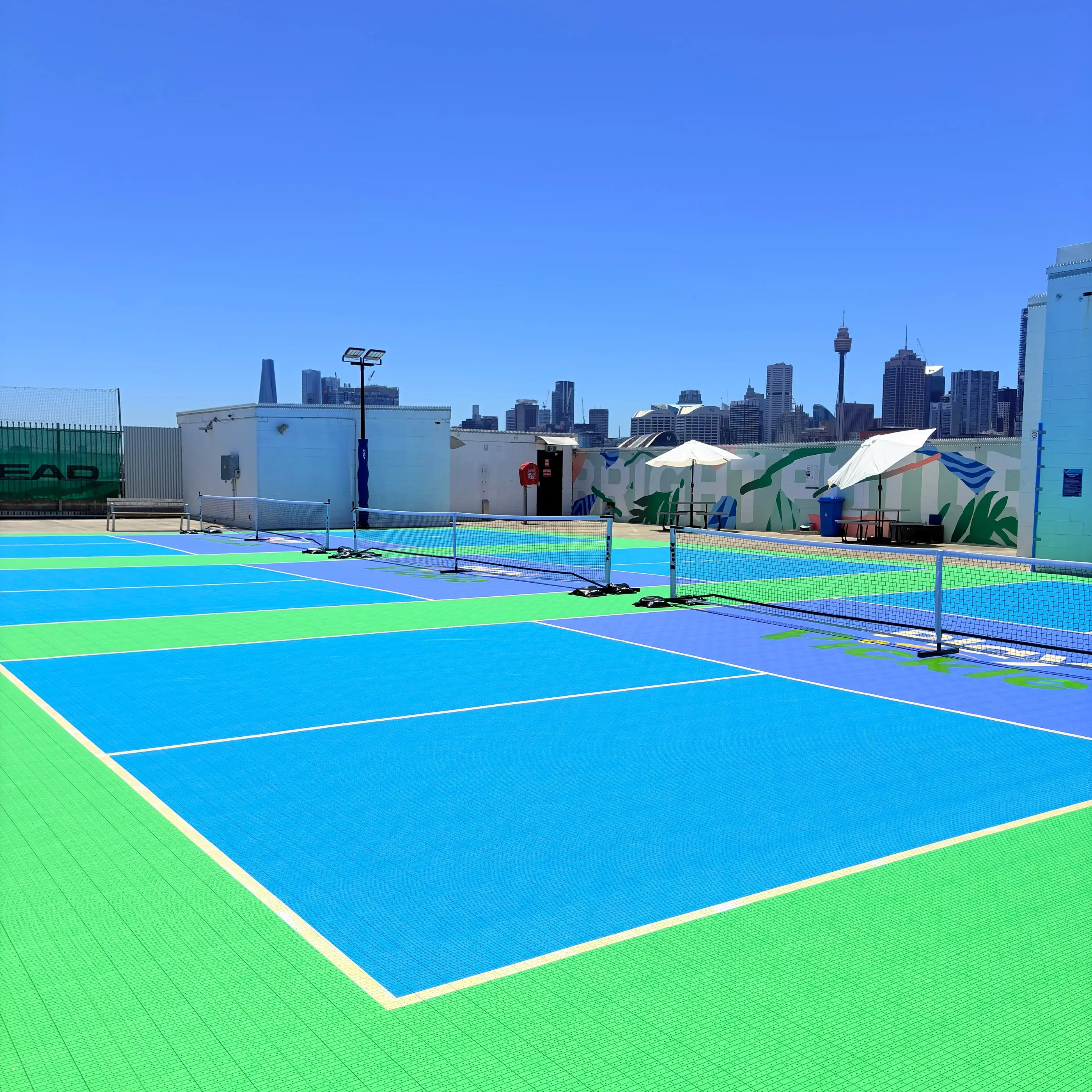 The rooftop pickleball courts at Broadway Sydney, with Sydney Tower and the CBD skyline on the horizon